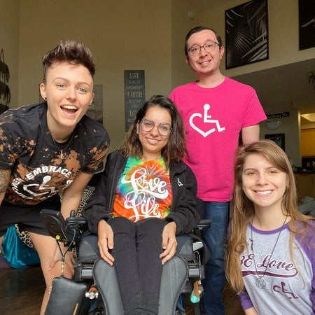 Sawsan surrounded by smiling family wearing 3E Love gear